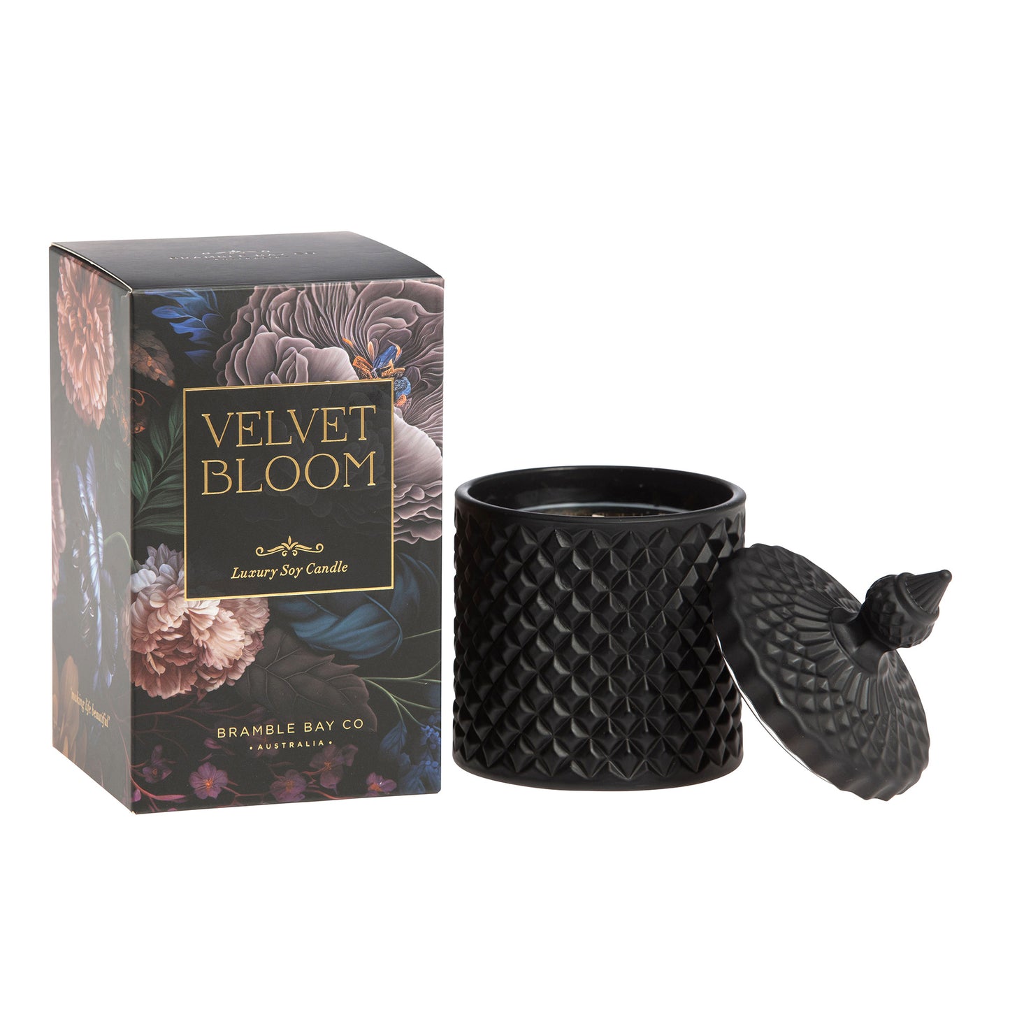 A black, textured Bramble Bay Co scented candle with a geometric pattern, accompanied by its packaging that features floral artwork and the name 'Velvet Bloom'.