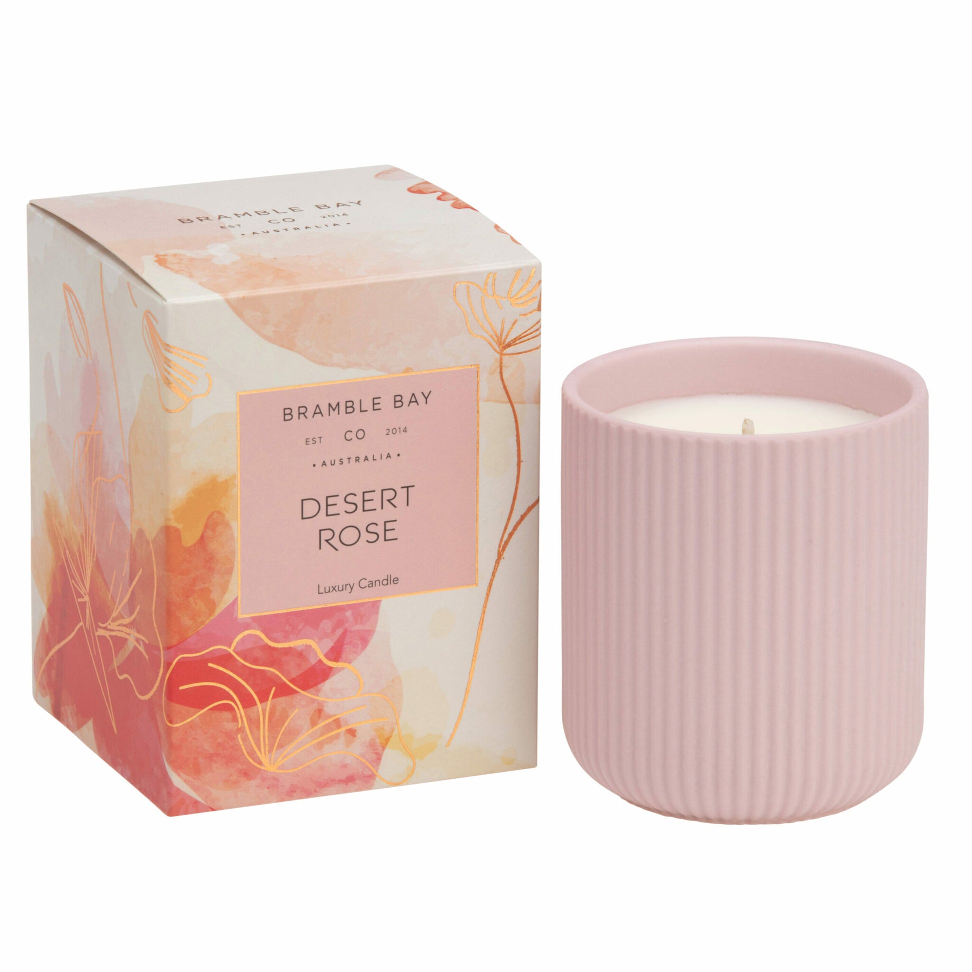 A Bramble Bay Co Desert Rose ceramic candle jar with a striped pattern in a pink hue, alongside its packaging box which has floral and abstract designs in muted colors.
