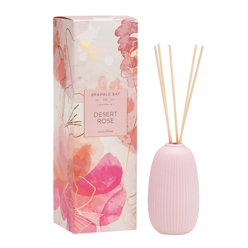 A Bramble Bay Co pink ceramic diffuser with fluted design, accompanied by a box with 'Desert Rose' written on it, indicating the fragrance.