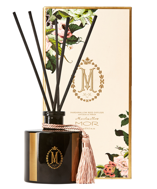 A black reed diffuser with a tassel on top, inside a square-shaped glass jar with a black lid. The product is adorned with a floral pattern and has the 'Mor' brand logo.