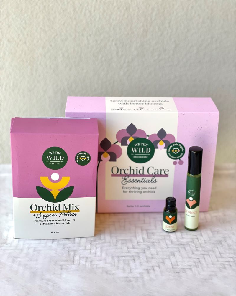 A gift pack for orchid care containing a bag labeled 'Orchid Mix', a spray bottle, and a book titled 'Orchid Care Essentials'.