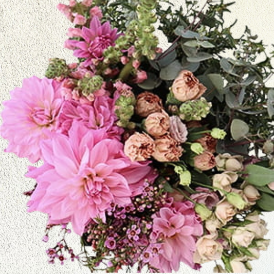 A bouquet of pastel blush flowers including pink and green blooms, arranged in a floral arrangement.
