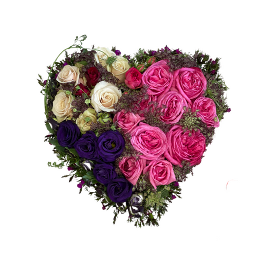 A heart-shaped floral arrangement with a mix of pink, purple, and white roses, and lissianthus flowers.
