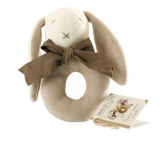 A beige and brown donut-shaped baby rattle with a soft plush texture, featuring a rabbit-like face with closed eyes, a brown bow tie, and a brown rattle ring. It is displayed next to a card with the brand name 'Maud n Lil'.