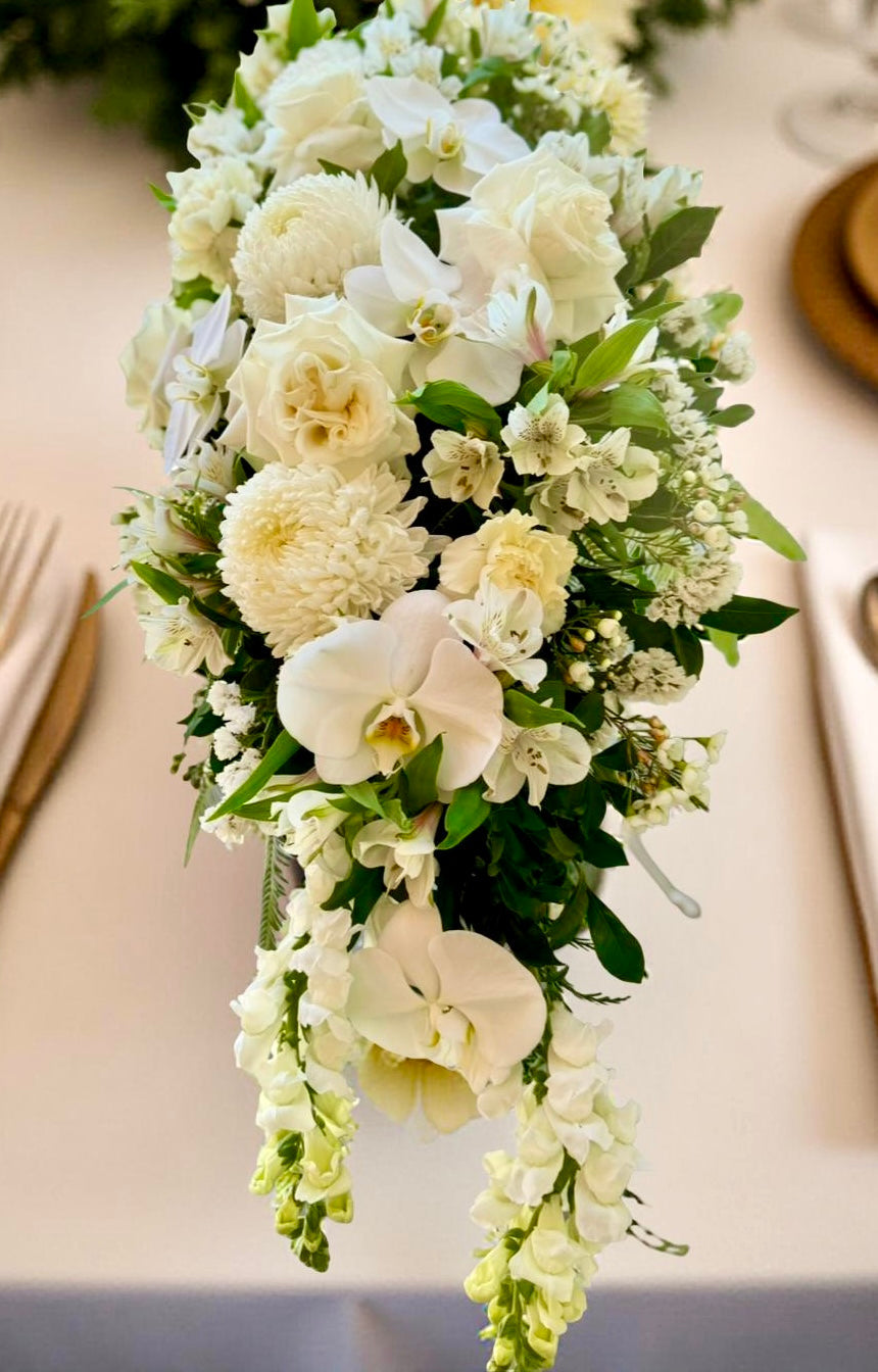 luxury white centrepiece containing roses, orchids and lush white flowers