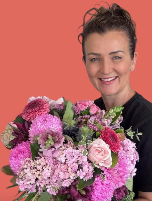 woman smiling holding a bouquet of flowers