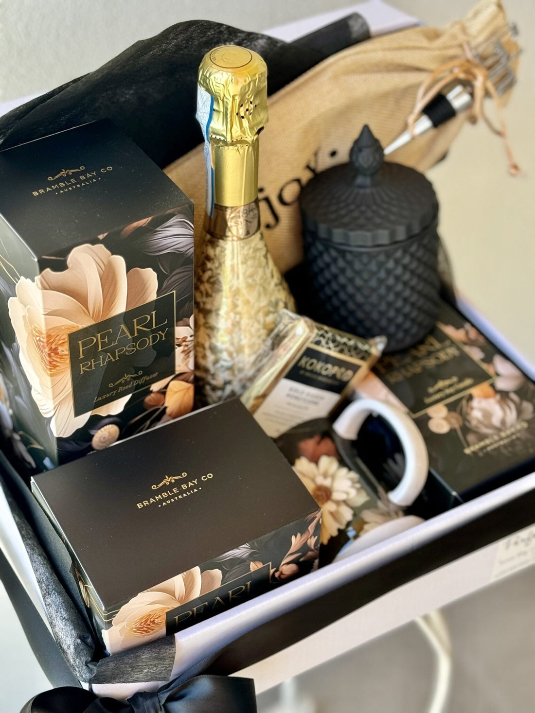 premium gift hamper of wine, scented candle, diffuser, matching mug and chocolates