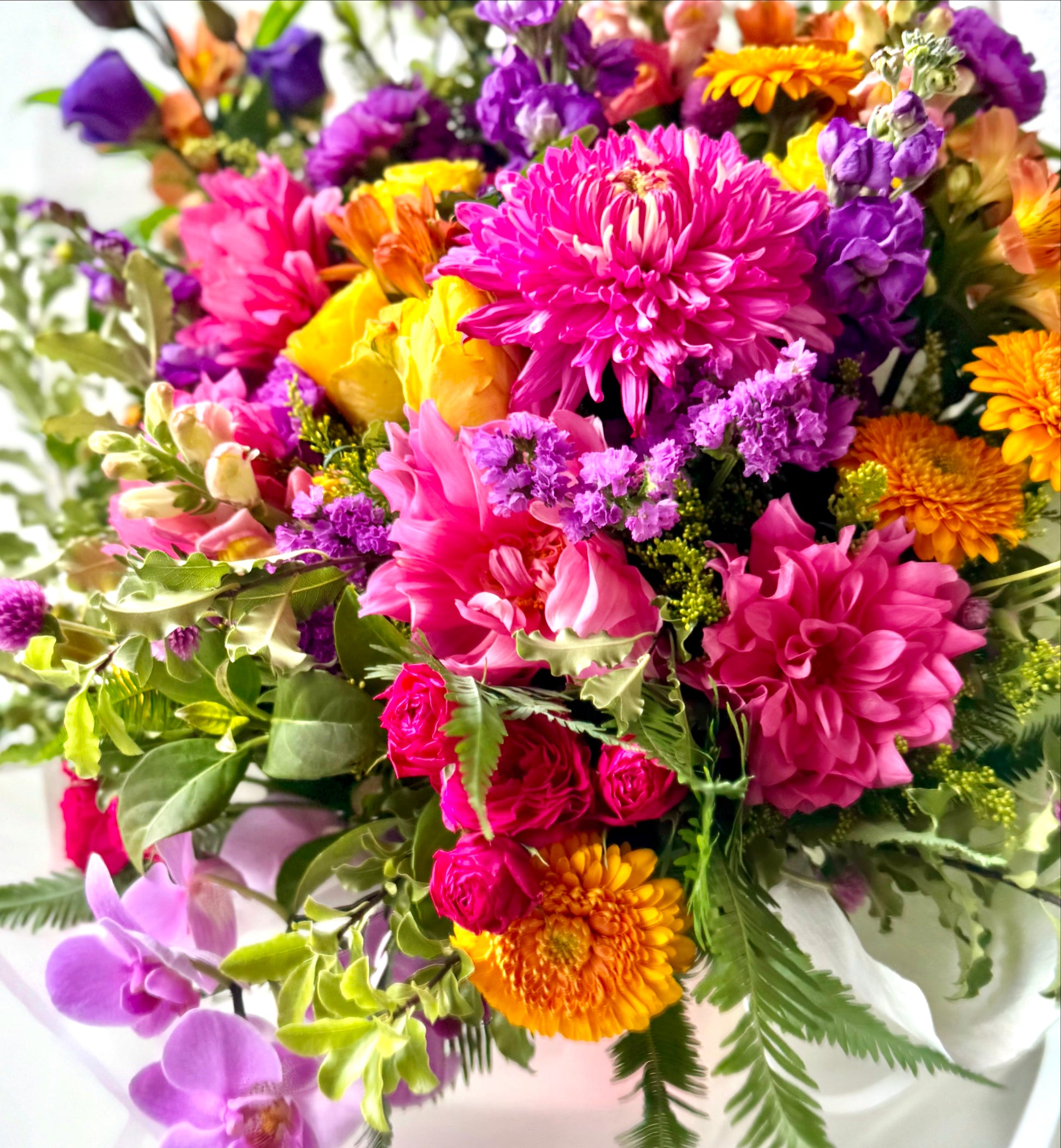 Bouquet of colourful flowers including pink, purple, yellow, orange and green.