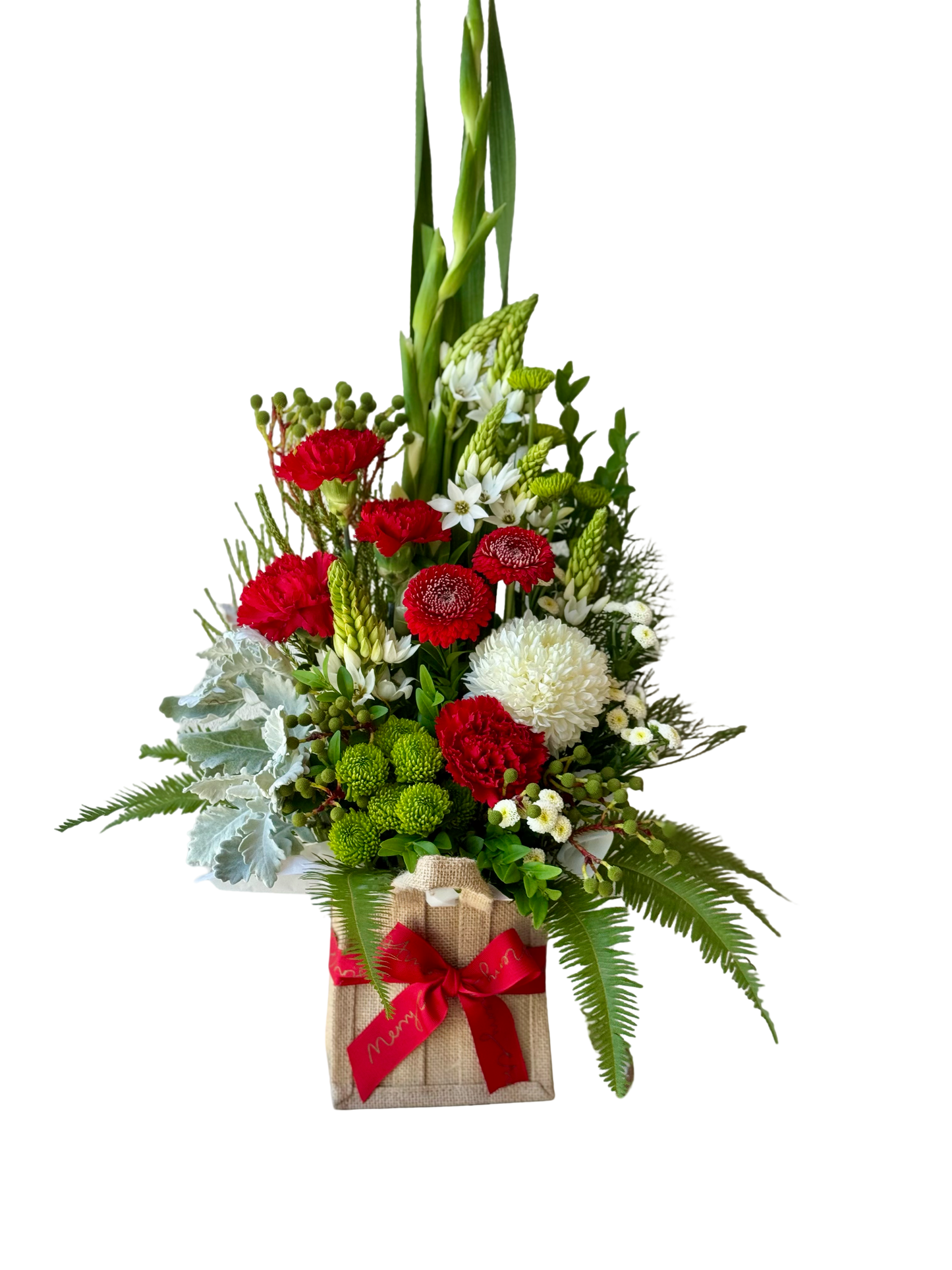 Christmas flower arrangement in a hessian gift bag with red, white and green festive blooms and a red ribbon.