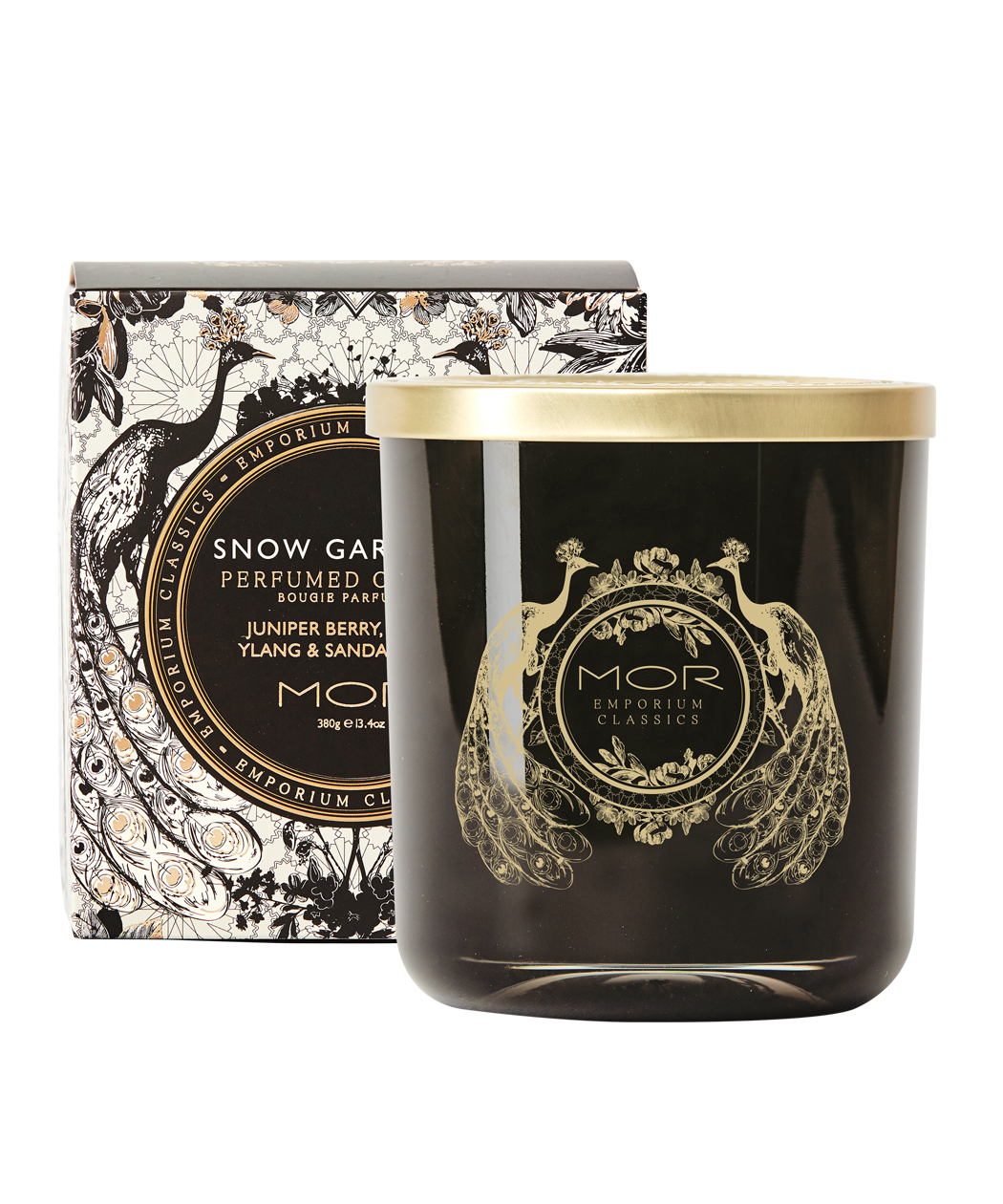 A MOR deluxe soy candle with a black wax and gold embellishments, hand poured into a gold rimmed glass vessel with a decorative lid, presented with a box packaged in black and white floral patterned paper.