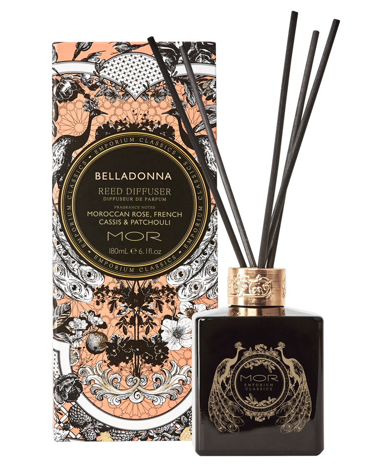 A black glass reed diffuser with gold and white floral patterns and a gold diffuser cap, alongside its decorative box with similar designs.