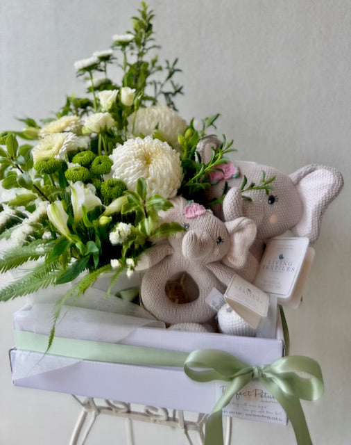 Newborn baby gift hamper including white floral arrangement with Living Textiles Ella the Elephant cuddle toy and matching rattle.