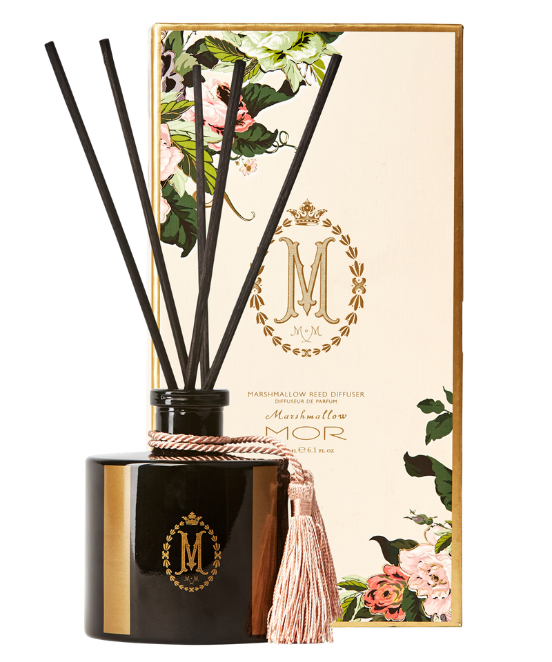 A black reed diffuser with a tassel on top, inside a square-shaped glass jar with a black lid. The product is adorned with a floral pattern and has the 'Mor' brand logo.