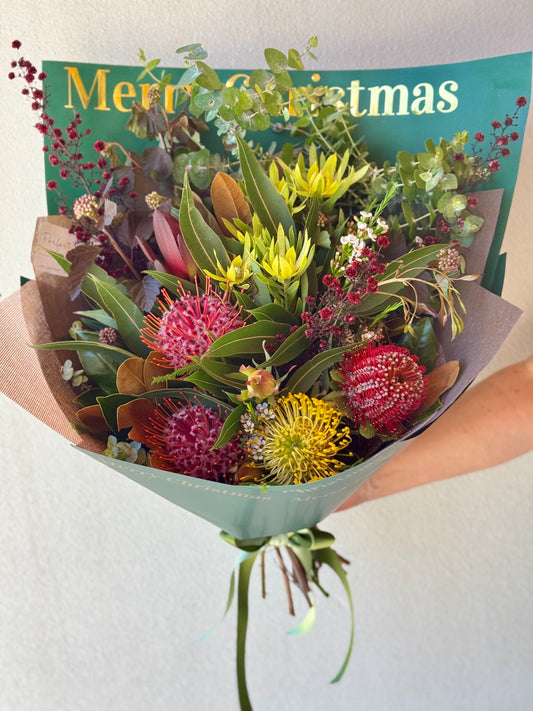 Bouquet of native flowers wrapped in Merry Christmas paper
