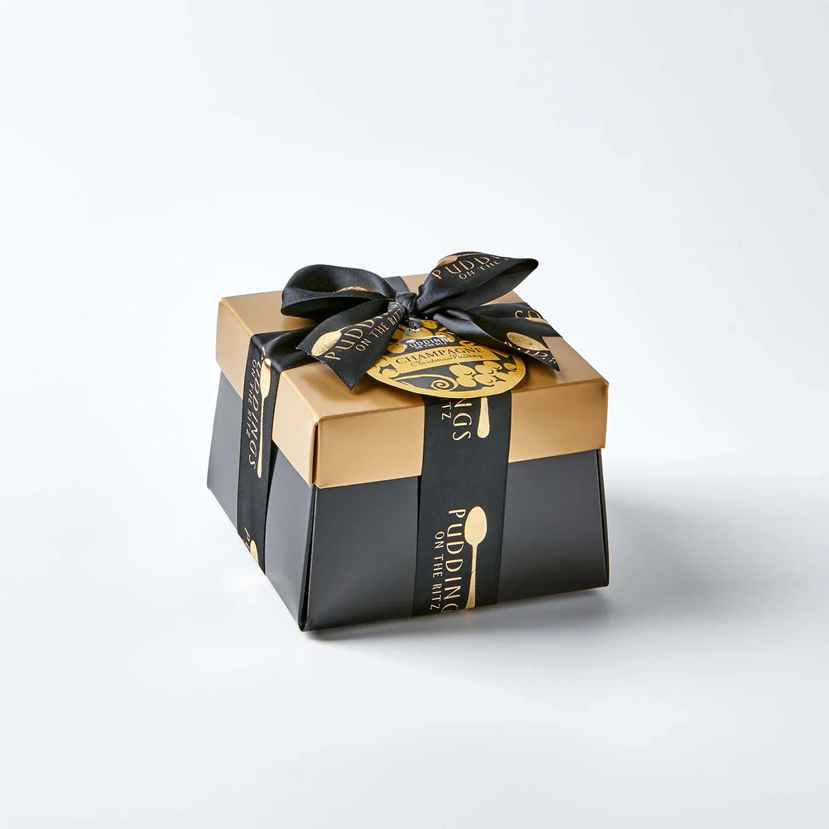 Gift box of Christmas Champagne pudding with black and gold ribbon on a white background