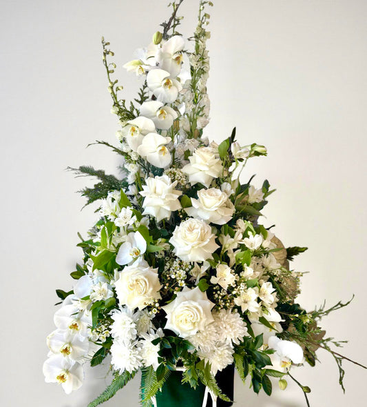 Tall white orchid and rose event floral arrangement in pedestal style