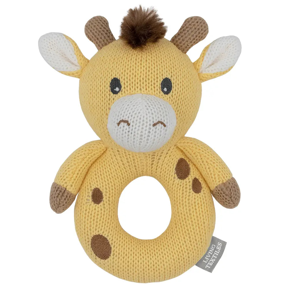 A yellow knitted giraffe rattle with brown spots, a ring for easy grip, and a brown plush tuft at the top.