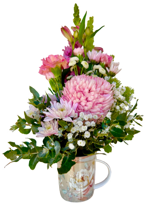 Bouquet of pink and white flowers in a decorative mug on a white background