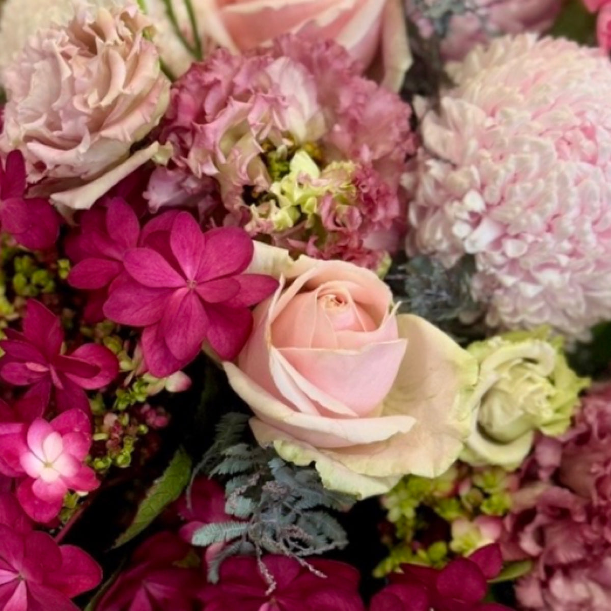 Pretty in Pinks floral arrangement featuring feminine pink seasonal blooms in a premium Perfect Petals style