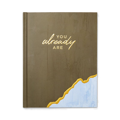 A book with a beige and blue cover featuring the title 'You Already Are' in gold lettering.